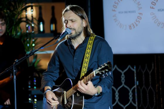Roman Kuzmin vom Unternehmen TECE singend und Gitarre spielend beim Get-together der Foster Magazine Veranstaltung.